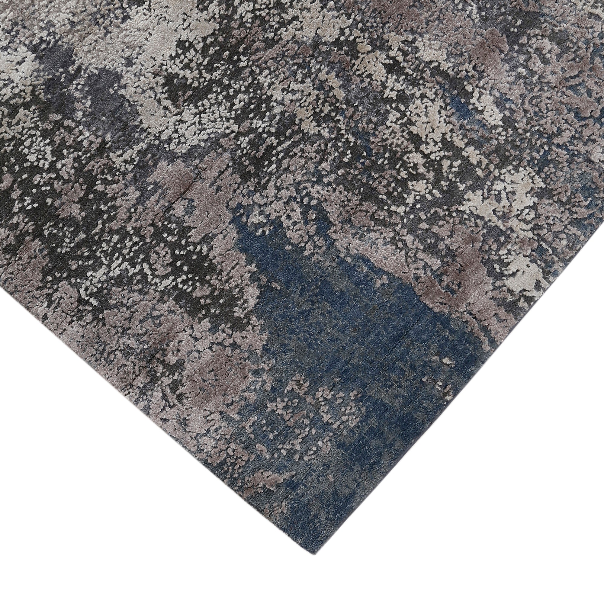 Hand-finished edge and textured abstract surface of the Silvermist Cascade hand knotted modern rug