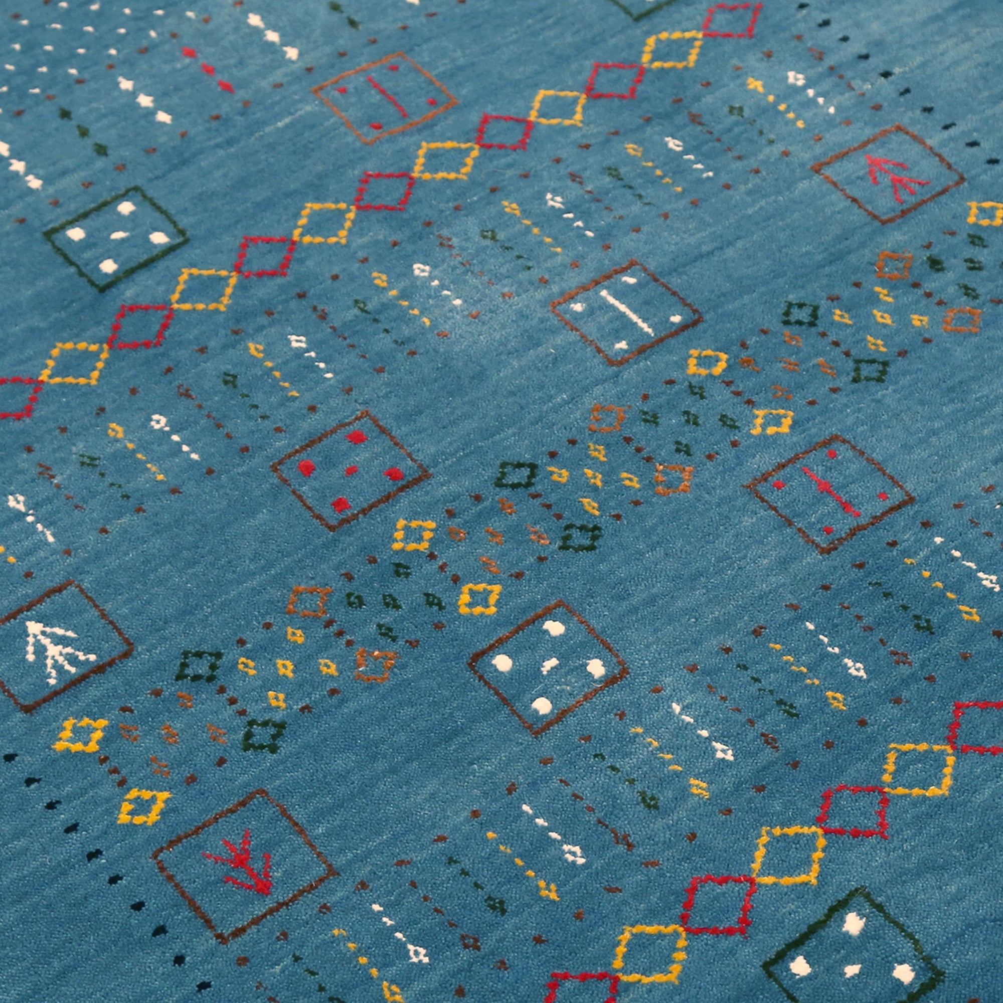 Close-up texture of teal blue Hand Woven Loom Lori wool rug showing natural wool fibres and geometric motif detailing