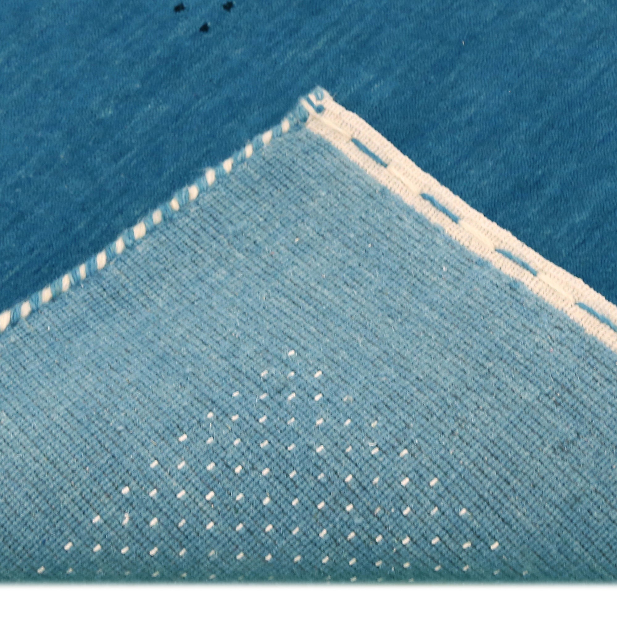 Corner and edge detail of teal blue Hand Woven Loom Lori wool rug showing decorative border and handcrafted finishing