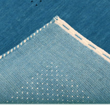Corner and edge detail of teal blue Hand Woven Loom Lori wool rug showing decorative border and handcrafted finishing