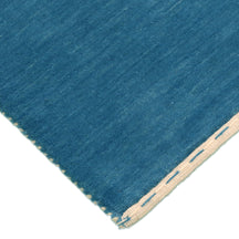 Corner and edge detail of teal blue Hand Woven Loom Lori wool rug showing natural wool texture and handcrafted finishing