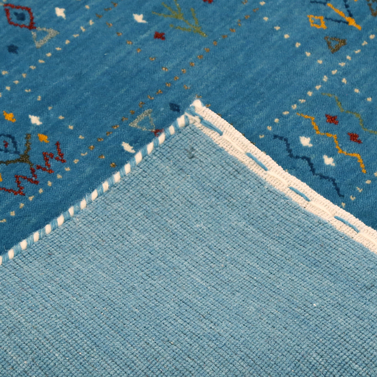 Corner and edge detail of teal blue Hand Woven Loom Lori wool rug showing natural wool texture and handcrafted finishing