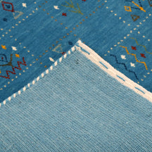 Corner and edge detail of teal blue Hand Woven Loom Lori wool rug showing natural wool texture and handcrafted finishing