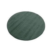 Angled perspective view of Teal Green Hand Woven Loom Lori round wool rug showing its circular shape and textured surface.