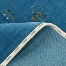 Close-up of teal blue Hand Woven Loom Lori wool rug showing dotted panels, geometric symbols and natural handcrafted wool texture
