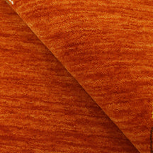 Close-up of rust orange Hand Woven Loom Lori wool rug showing central diamond motif, colourful folk details and natural wool texture