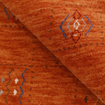 Close-up of burnt orange Hand Woven Loom Lori wool rug showing natural wool texture and multicolour tribal geometric motifs